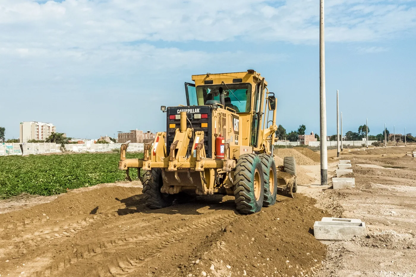 A grader levelling a cleared residential block ready for construction to begin.